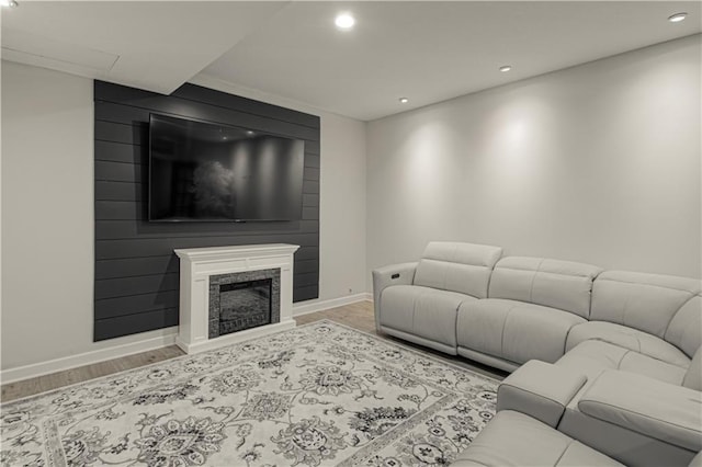 living room featuring recessed lighting, baseboards, wood finished floors, and a fireplace