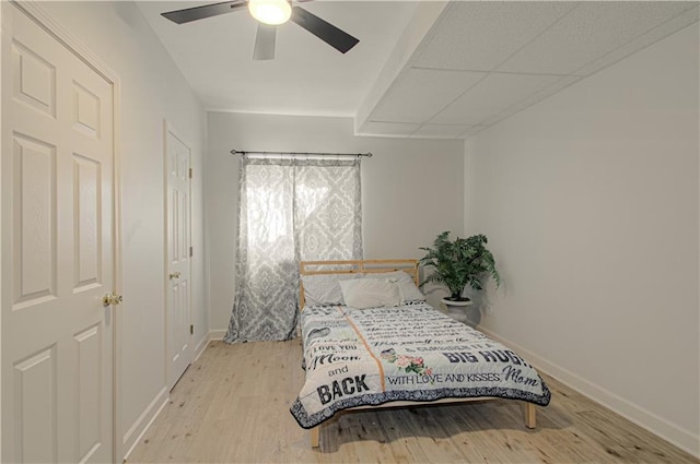 bedroom featuring light wood-style floors, baseboards, and ceiling fan