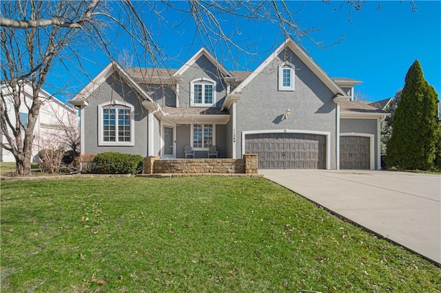 traditional-style home featuring concrete driveway, an attached garage, a front yard, and stucco siding