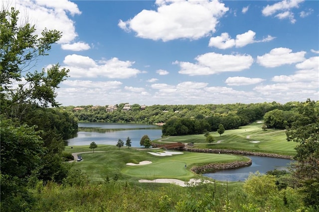 view of community with golf course view, a water view, and a yard