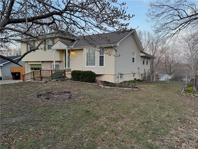 split level home with a front yard, a gate, and fence