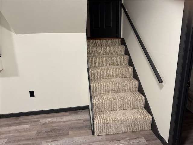 stairway featuring baseboards and wood finished floors