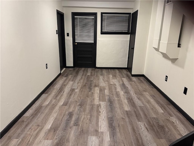 empty room featuring baseboards and wood finished floors