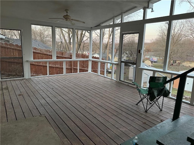 unfurnished sunroom with a ceiling fan and vaulted ceiling