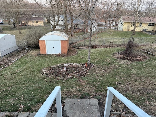 view of yard featuring an outbuilding, a storage unit, and a fenced backyard