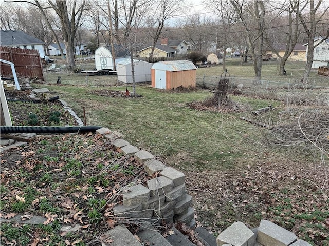 view of yard featuring a storage unit, an outbuilding, and fence