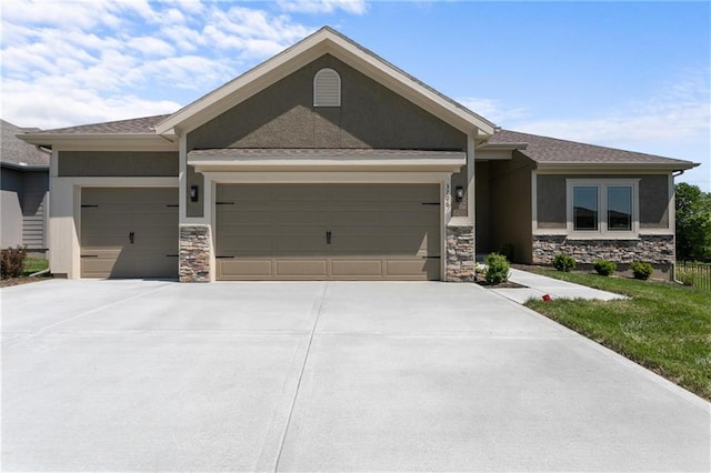 view of front facade with concrete driveway, an attached garage, stone siding, and stucco siding