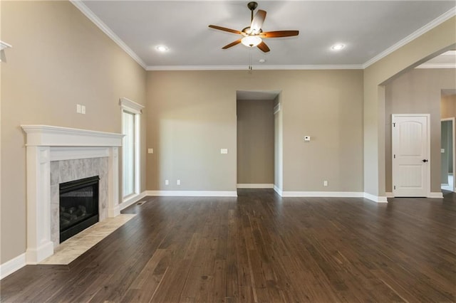 unfurnished living room with dark wood finished floors, crown molding, baseboards, and a high end fireplace