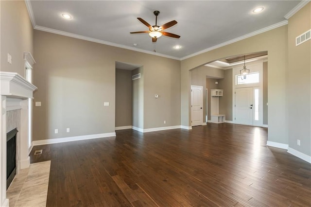 unfurnished living room with visible vents, a fireplace with flush hearth, wood finished floors, and crown molding