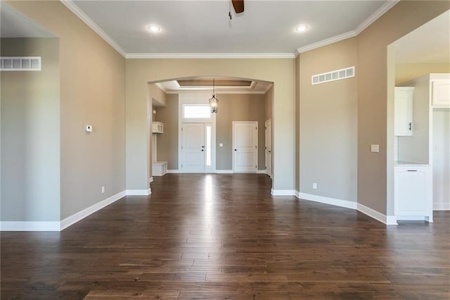 unfurnished room featuring dark wood-style floors, visible vents, arched walkways, and ornamental molding