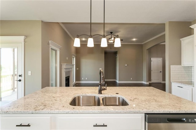 kitchen with a sink, stainless steel dishwasher, a fireplace, and crown molding