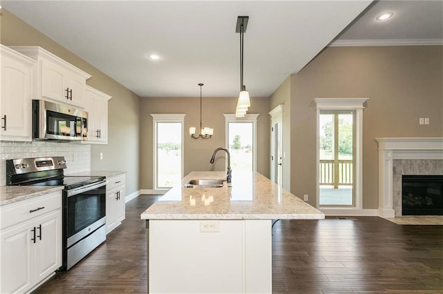 kitchen featuring tasteful backsplash, a tiled fireplace, appliances with stainless steel finishes, dark wood-style floors, and a sink