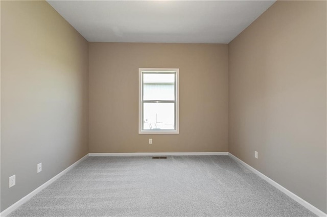 spare room featuring visible vents, carpet, and baseboards