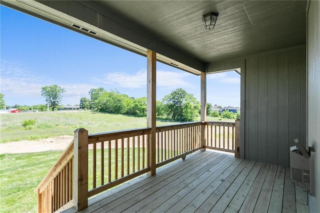 wooden deck featuring a lawn