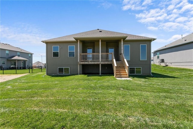 rear view of house featuring a yard and fence