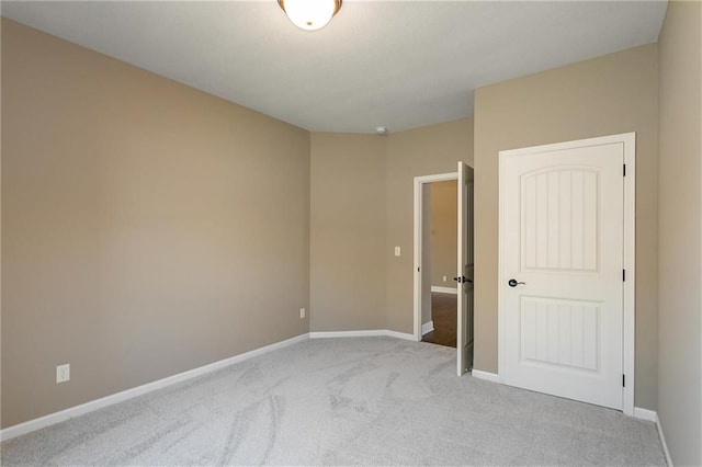 unfurnished bedroom featuring light colored carpet and baseboards