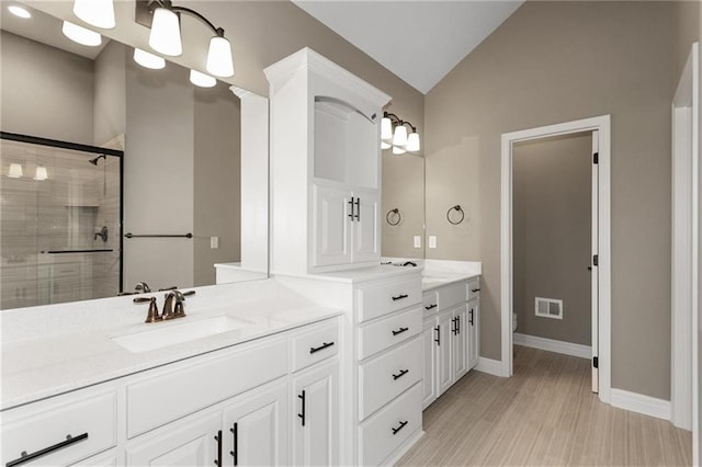 full bath with visible vents, toilet, lofted ceiling, a stall shower, and vanity