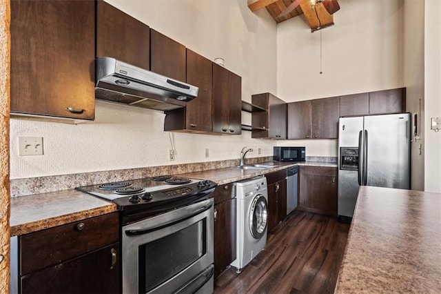308 W 8th St Unit 414, Kansas City, MO 64105 - kitchen featuring under cabinet range hood, washer / dryer, stainless steel appliances, dark wood-type flooring, and dark brown cabinets