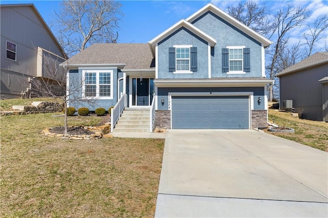 split level home featuring driveway, an attached garage, stucco siding, a front lawn, and stone siding