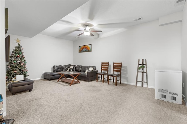 carpeted living room featuring visible vents, baseboards, and ceiling fan