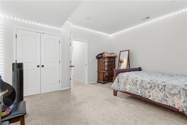 bedroom with visible vents, baseboards, carpet, and a closet