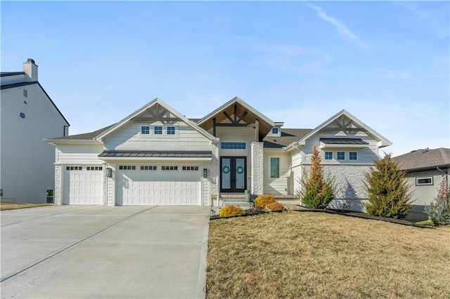 view of front facade with an attached garage, french doors, concrete driveway, and a standing seam roof