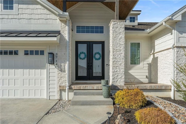 view of exterior entry featuring french doors, a garage, and roof with shingles