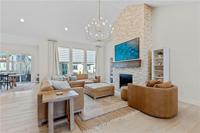 living area featuring a wealth of natural light, a notable chandelier, wood finished floors, and high vaulted ceiling