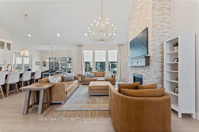 living area featuring a healthy amount of sunlight, high vaulted ceiling, and an inviting chandelier