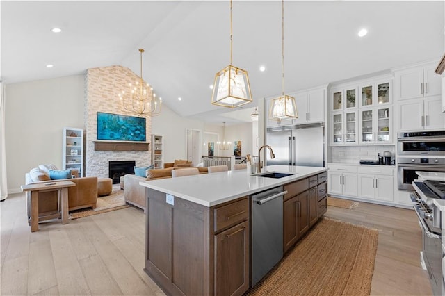 kitchen featuring white cabinets, stainless steel appliances, light countertops, and a sink