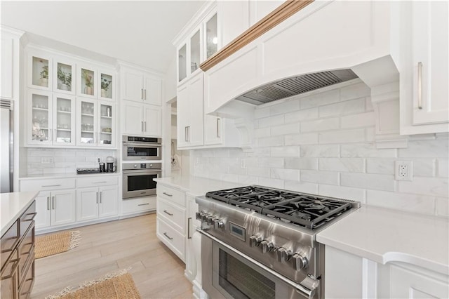 kitchen with premium appliances, white cabinets, and light countertops