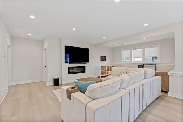 living area featuring recessed lighting, light wood-type flooring, and baseboards