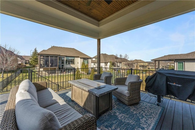 wooden terrace with outdoor lounge area, area for grilling, a residential view, and a sunroom