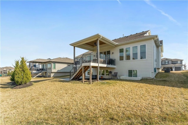 back of house with ceiling fan, stairway, a residential view, central AC unit, and a yard