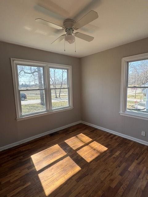 unfurnished room with dark wood finished floors, ceiling fan, and baseboards