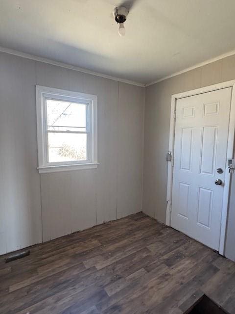 spare room with crown molding and dark wood-style floors