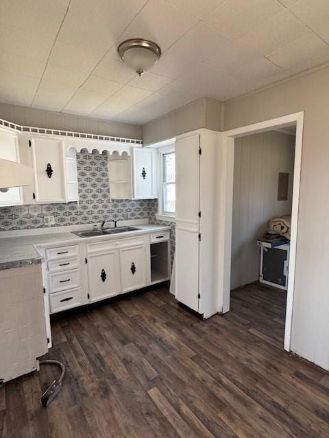 kitchen featuring white cabinetry, dark wood-type flooring, light countertops, and a sink