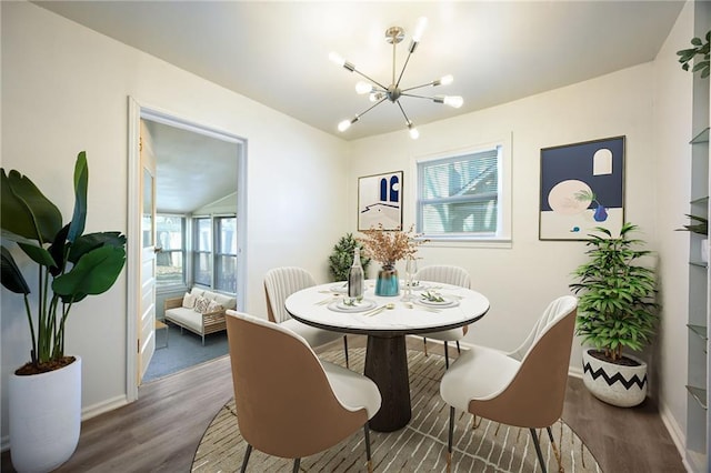 dining space featuring plenty of natural light, baseboards, an inviting chandelier, and wood finished floors