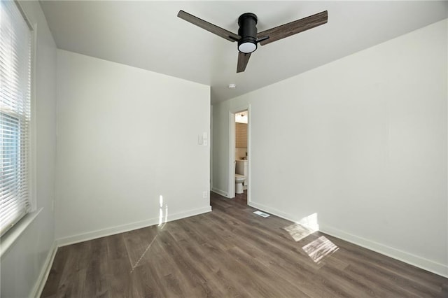 empty room featuring dark wood finished floors, baseboards, and ceiling fan