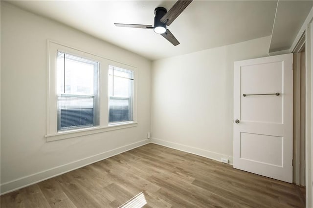 unfurnished room featuring wood finished floors, baseboards, and ceiling fan