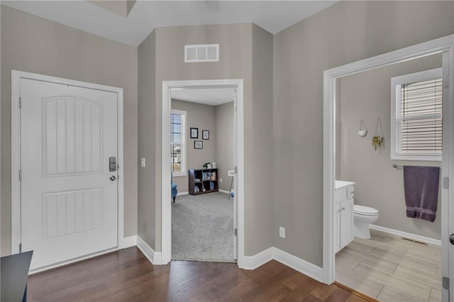 entrance foyer with visible vents, baseboards, and wood finished floors