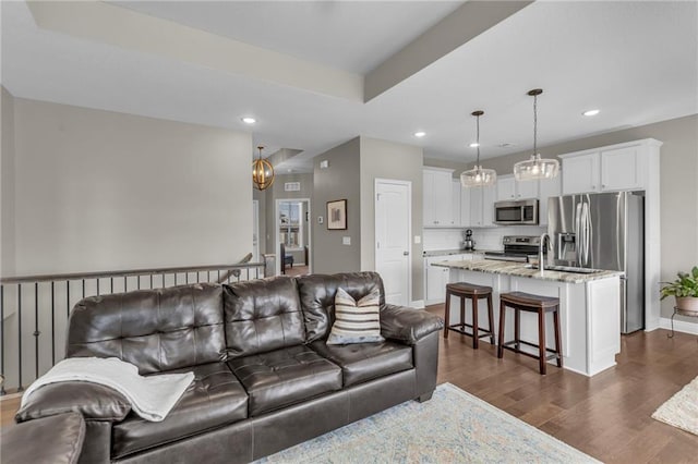 living room featuring recessed lighting, baseboards, and dark wood-type flooring