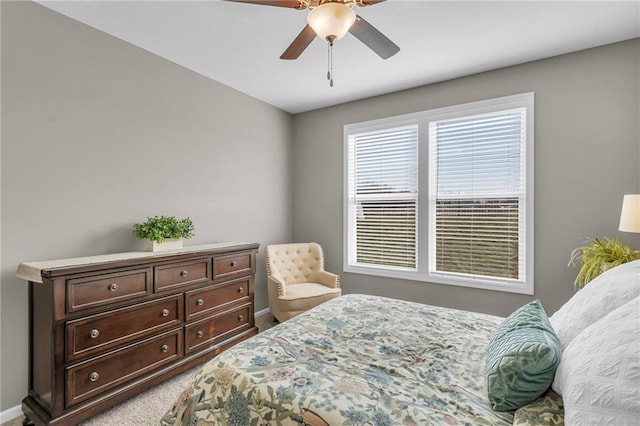 bedroom featuring baseboards, light carpet, and ceiling fan