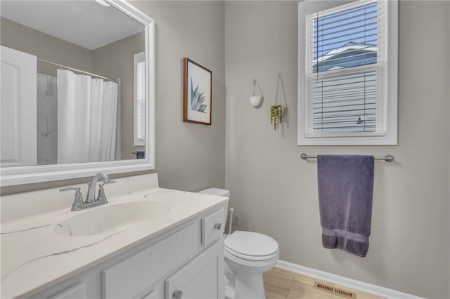 bathroom with visible vents, curtained shower, baseboards, toilet, and vanity