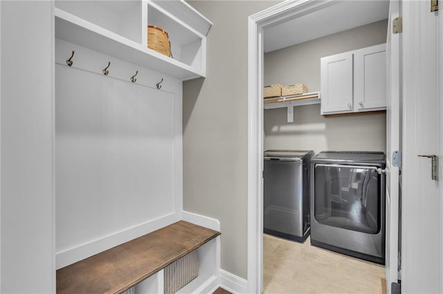 laundry room featuring baseboards, cabinet space, and washer and clothes dryer