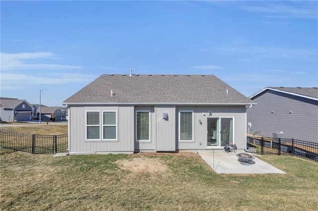 rear view of property with a patio, a fenced backyard, an outdoor fire pit, a yard, and a shingled roof