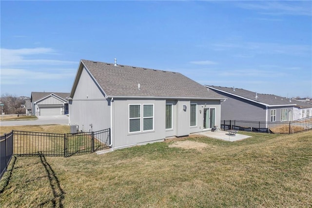 rear view of house with a yard, a patio area, a fenced backyard, and a shingled roof