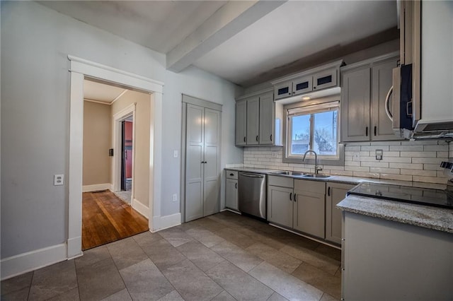 kitchen featuring baseboards, beam ceiling, decorative backsplash, appliances with stainless steel finishes, and a sink