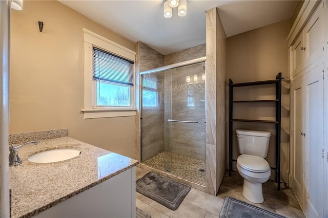 bathroom featuring vanity, toilet, a stall shower, and tile patterned flooring