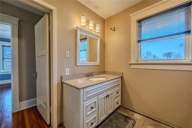 bathroom with vanity, wood finished floors, and baseboards